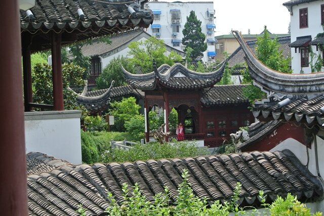 <p>
	Einige Gebäude im Park im traditionellen chinesischen Stil mit einer Flötenspielerin für die Touristen</p>
