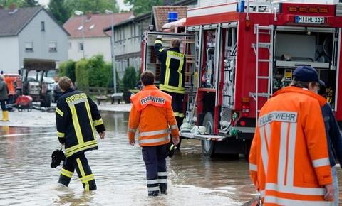 <p>
	Feuerwehrkräfte stehen auf einer vom <span class="suchwort">Hochwasser</span> überfluteten Straße in Söhlde im Landkreis Hildesheim (Niedersachsen).</p>
