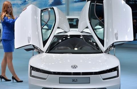 <p>
	Eine Hostess öffnet die Türen des 1-Liter-Autos von Volkswagen, dem XL1.</p>
