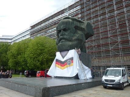 <p>
	Der wohl größte Fan der deutschen Fußball-Nationalmannschaft steht in Chemnitz. Am Donnerstag wurde der Sockel des Karl-Marx-Monuments mit einer Kunststoffplane in Trikot-Optik verhüllt.</p>
