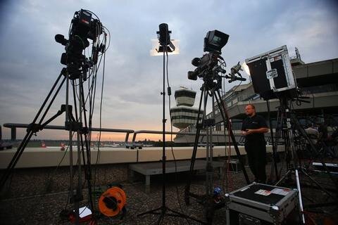 <p>
	Fotografen und Kamerateams warten in den frühen Morgenstunden am Dienstag auf die Ankunft der Nationalmannschaft am Flughafen Berlin-Tegel.</p>
