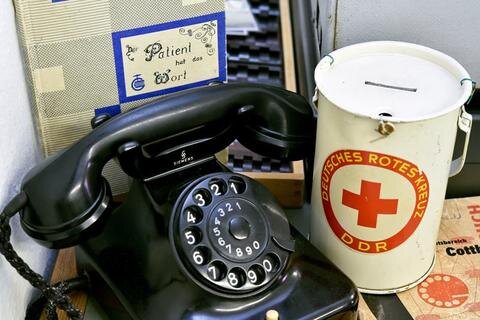 <p>
	<span class="Text">Ein Telefon mit Wählscheibe und eine Spendenbüchse vom Deutschen Roten Kreuz. </span></p>
