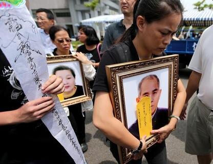 <p>
	In einer buddhistischen Zeremonie erinnern die Angehörigen an die Opfer, die auf Porträts abgebildet sind.</p>
