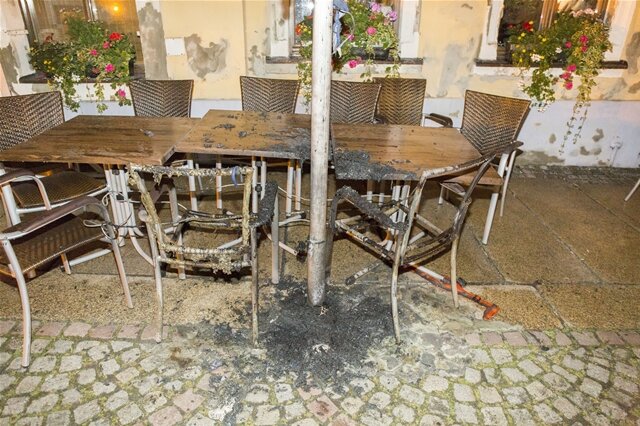 <p>
	Unbekannte haben am Samstag in einem Biergarten am Markt zwei Sonnenschirme, vier Tische sowie vier Stühle in Brand gesetzt.</p>
