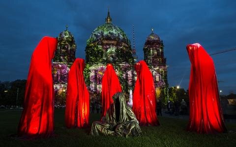 <p>
	Das Kunstwerk &quot;Die Wächter der Zeit&quot; stehen im Rahmen des Festival of Lights vor dem erleuchteten Dom.</p>
