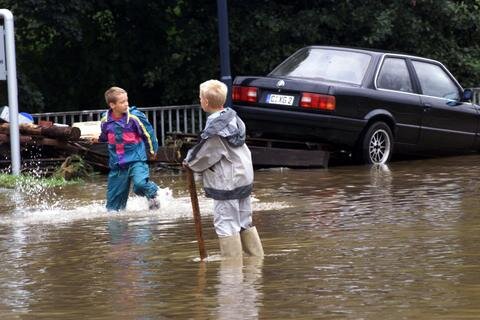 Kinder stehen im Hochwasser im Stadtteil Erfenschlag.