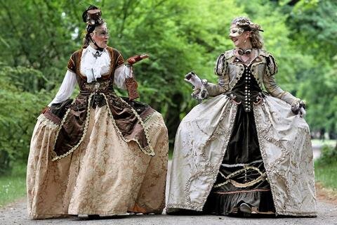 <p>
	Sonja aus Würzburg (r.) und Sabine aus Frankfurt/Main spazieren in viktorianischen Kleidern durch einen Park.</p>
