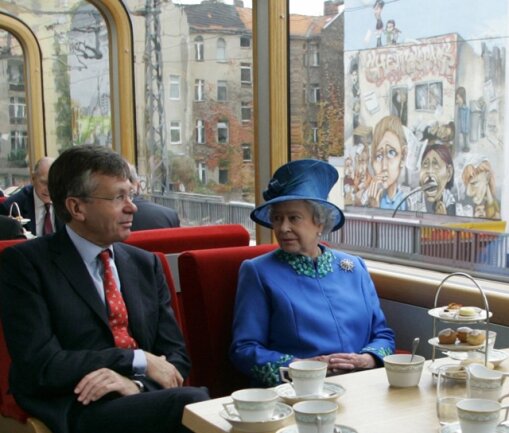 <p>
	Königin Elizabeth II. und der britische Botschafter in Deutschland, Peter Torry, fahren 2004 in einem Panoramazug der S-Bahn von Berlin nach Potsdam.</p>
