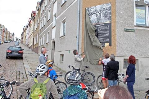 <p>
	Die Gedenktafel am Fuße der &quot;Steilen Wand&quot; wird enthüllt. Förderer, Freunde und Fans des Radsports der Region werfen einen ersten Blick auf die Tafel.</p>
