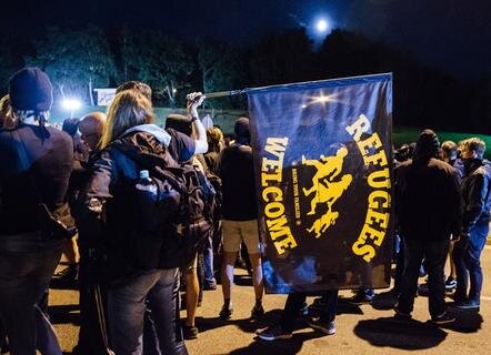 <p>
	Linke Demonstranten standen am Sonntagabend vor dem ehemaligen Praktiker-Baumarkt auf der Straße.</p>
