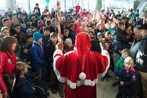 <p>
	Danach schritt der Alte in seinem roten Mantel und dicht umringt von Kindern durch das Terminal und verteilte kleine Geschenke. Auch ein Weihnachtsengel und ein Elch erfreuten die Kinderherzen. Lieder und Gedichte rundeten den Auftritt ab.</p>
