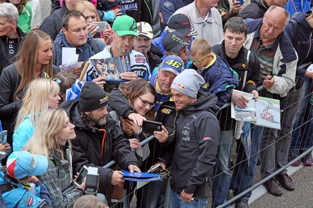 <p>Am Nachmittag stürmten Tausende Fans die Boxengasse, um den Stars der Motorrad-Weltmeisterschaft ganz nah zu sein. (Im Bild: Sandro Cortese bei seinen Fans.)</p>

