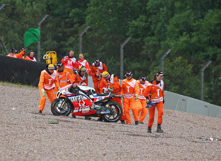 <p>Die Streckenposten der Kurve 11 mit der Ducati von Scott Redding beim ersten Training der MotoGP.</p>
