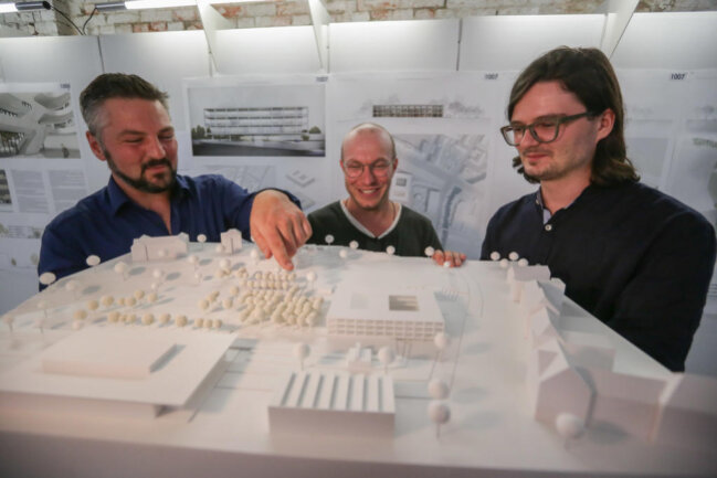 <p>Geschäftsführer Peter Jarisch mit Michael Klemm und Michael Baer (von links) vom Architektenbüro Code Unique Architekten aus Dresden am Modell ihres Siegerentwurfs. Vorn links: neue und alte Hartmannhalle.</p>
