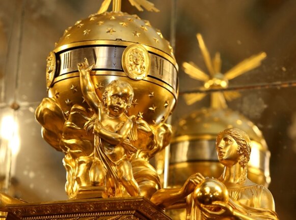 <p><strong>6. November:</strong>&nbsp;Bislang stand sie auf dem Kaminsims im Blauen Saal des Schlosses Waldenburg und fiel niemandem auf. Dabei kann man davon ausgehen, dass die eigenartig anmutende Uhr seit mehreren Jahrzehnten dort ihren Platz hatte. Doch erst jetzt, nachdem sie restauriert wurde, erstrahlt sie in goldenem Glanz. Und sie dürfte nach Einschätzung von Restaurator Thomas Heinicke auf der Welt einmalig sein. Die feuervergoldete Bronzeuhr wurde um 1810 in Paris gebaut, die erste Besonderheit ist ihre Größe – immerhin 1,30 Meter. Normalerweise wurden damals Konsoluhren gebaut, die um die 50 Zentimeter hoch waren. „Wir gehen davon aus, dass dieses Stück eine Einzelanfertigung für Napoleon I. gewesen ist“, sagt Restaurator Heinicke. Fünf bis sechs Leute haben seiner Auffassung nach mindestens ein Jahr lang an dem Schmuckstück gearbeitet. Den Wert dieses Kunstwerkes zu benennen, damit tut sich der Restaurator schwer, denn es gebe aufgrund der Einmaligkeit nichts Vergleichbares auf dem Markt. Heinicke konnte weder in der Literatur noch beim Besuch im Pariser Louvre Derartiges finden.</p>
