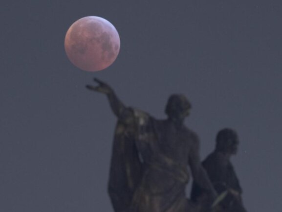 <p>Der Vollmond zeigt sich hinter einer Mattielli-Statue in Dresden, während er in den Kernschatten der von der Sonne angestrahlte Erde tritt.</p>
