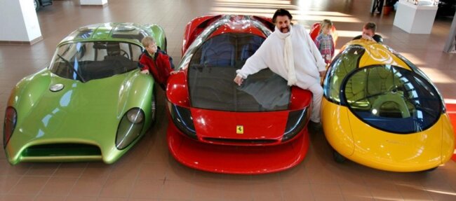 <p>2006: Luigi Colani mit seinem&nbsp; Stadtauto (r.), einem Ferrari Testarossa (M.), mit dem er einen Weltrekord von 387 km/h gefahren hat, und einem Speedster auf Basis eines VW-Käfers von 1968/69 (l.) in einem Autohaus. Das "gelbes Ei" genannte Stadtauto ist 350 Kilogramm schwer, kann mit Elektroantrieb, Biomassediesel und Uniwankelmotor gefahren werden und erreicht eine Geschwindigkeit von 125 km/h.</p>
