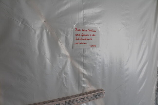 <p>Kunststoffplanen, Klebeband, Holzleisten und Stop-Schilder trennen die Corona-Isolierstation vom Rest des Krankenhauses in Freiberg.</p>
