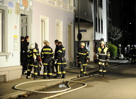 Feuerwehrmänner sichern in Lörrach den Eingang des Hauses, in dem in den Abendstunden eine Explosion stattgefunden hatte. 