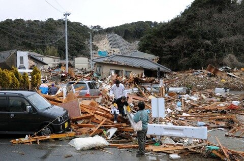 <p>
	Einwohner klettern über die Trümmer von zerstörten Häusern in Iwaki, Fukushima.</p>
