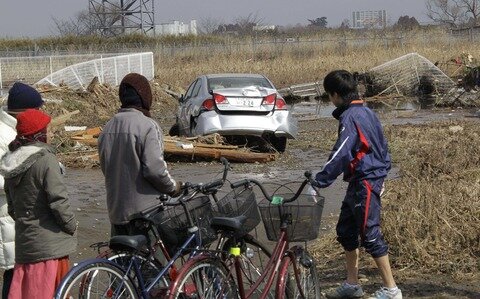 <p>
	Menschen schauen auf das zerstörte Sendai.</p>
