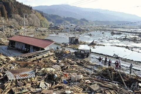 <p>
	Rettungskräfte vor zerstörten Häuser in Rikuzentakada.</p>
