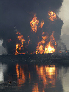 <p>
	Blick auf eine brennende Raffinerie in Tagajo.</p>
