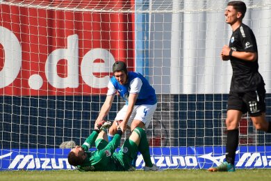 Damian Roßbach hilft Torwart Markus Kolke hoch. Der Rostocker Keeper patzte vor dem 1:1-Ausgleich.