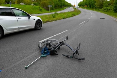 Ein beschädigtes Fahrrad liegt nach einem Unfall auf der B6 neben einem Auto.