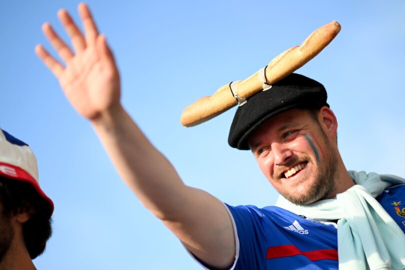 Das Baguette ist eines der großen Symbole Frankreichs. Man kann es essen - oder auch mal an der Mütze befestigen. Dieser Fan freut sich in Düsseldorf auf das EM-Spiel gegen Österreich.