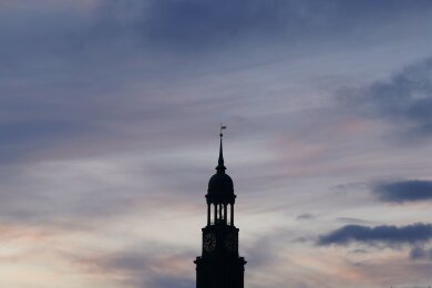 Die Turmspitze der Hamburger Hauptkirche Sankt Michaelis (Michel) ist vor dem abendlichen Himmel zu sehen.