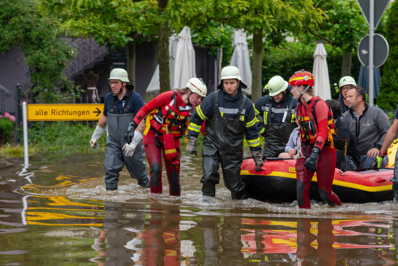 Mit einem Schlauchboot holen Feuerwehr und Wasserretter Anwohner aus ihren überfluteten Häusern in Wertingen (Bayern).