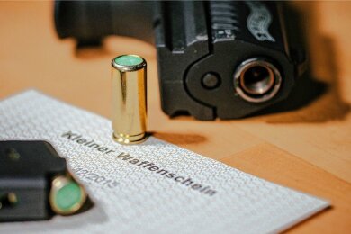 Ein kleiner Waffenschein liegt zwischen einer Schreckschuss-Pistole "Walther P22", einem Magazin und einer Platzpatrone. (Archiv)