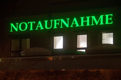 Der Schriftzug "Notaufnahme" hängt in leuchtendem Grün an einem Krankenhaus.