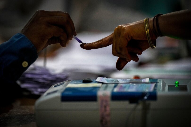 Ein Wahlhelfer markiert den Zeigefinger einer Frau mit unauslöschlicher Tinte, als sie während der indischen Parlamentswahlen im Dorf Bahona im nordöstlichen Assam zur Stimmabgabe erscheint.