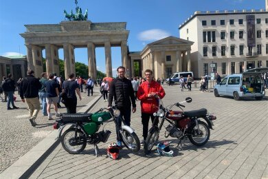 Elektro vs. Benzin: Jakob Wild und sein Mitarbeiter Lukas Kreskowsky mit Simson-Mopeds vor dem Brandenburger Tor in Berlin. Die linke hat einen E-Motor.