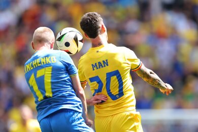 Ukraines Olexander Sintschenko und Rumäniens Dennis Man (r) kämpfen um den Ball.