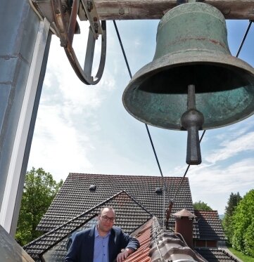 Stiftleiter Thomas Rüffer auf dem Dach mit der alten Glocke
