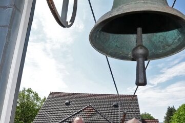 Stiftleiter Thomas Rüffer auf dem Dach mit der alten Glocke