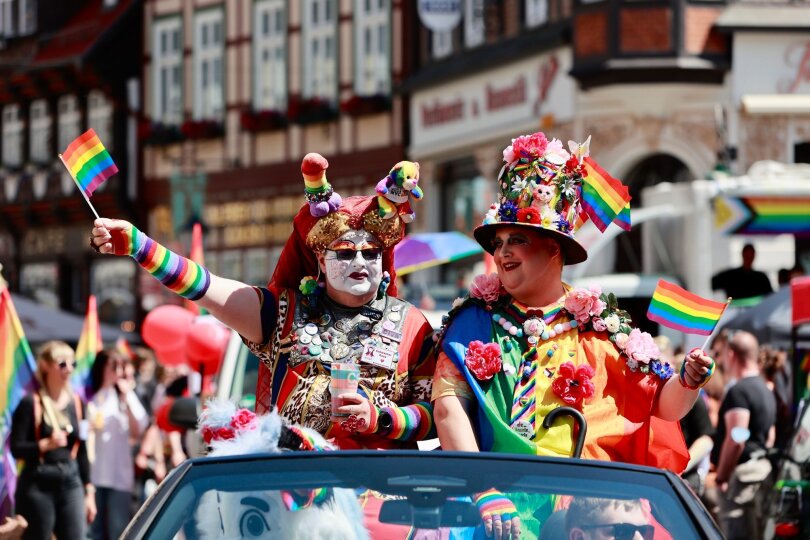 In Wernigerode, Sachsen-Anhalt, ziehen zahlreiche Teilnehmer beim Christopher Street Day durch die Stadt. So wie diese zwei Besucher, die sich per Auto dem Umzug anschließen.