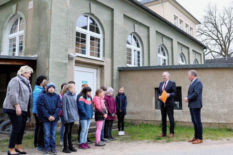 182.000 Euro Fördergeld fließen für die Grundschule in Lunzenau - Die Turnhalle erhält ein neues Dach und eine neue Fassade. Regionalminister Thomas Schmidt überbrachte dafür Bürgermeister Ronny Hofmann (r.) den Fördermittelbescheid im Beisein der Klasse 4a. 