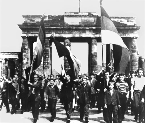 1953: Volksaufstand auch in Sachsen - Ost-Berliner marschieren am 17. Juni 1953 mit wehenden Fahnen vom Ost-Sektor aus durch das Brandenburger Tor. 