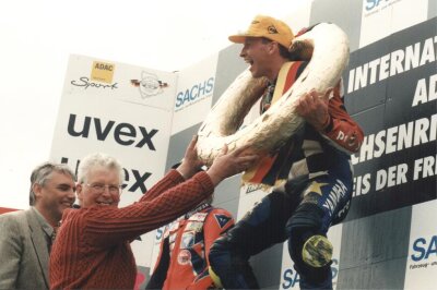 1996: Wieder Vollgas auf dem Sachsenring - Alan Shephard (2. v. l.), der ehemalige MZ-Werksfahrer aus Großbritannien, gratulierte gemeinsam mit Hohenstein-Ernstthals Bürgermeister Erich Homilius (l.) dem Sieger des Rennens der Klasse bis 250 ccm Matthias Neukirchen im Jahr 1996. 