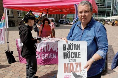 Gabi Engelhardt von Aufstehen gegen Rassismus Chemnitz mit einem Plakat, das das umstrittene Höcke-Motiv zeigt.