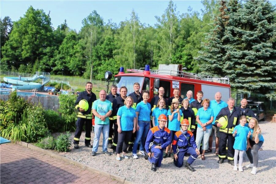 200 Jahre Feuerwehr in Rodau: Ort feiert und präsentiert historische Technik - Die Mitglieder der Feuerwehrlöschgruppe Rodau und des Waldbad-Fördervereins feiern gemeinsam vor der Kulisse des Freibades.