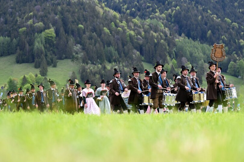 Im bayrischen Lenggries feiern Menschen den Patronatstag. Sie marschieren in Trachten durch die Landschaft und feiern die Muttergottes, die ihre Schutzpatronin ist.