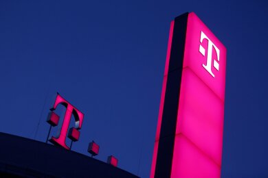 Das Logo der Deutschen Telekom leuchtet auf dem Dach der Unternehmenszentrale.