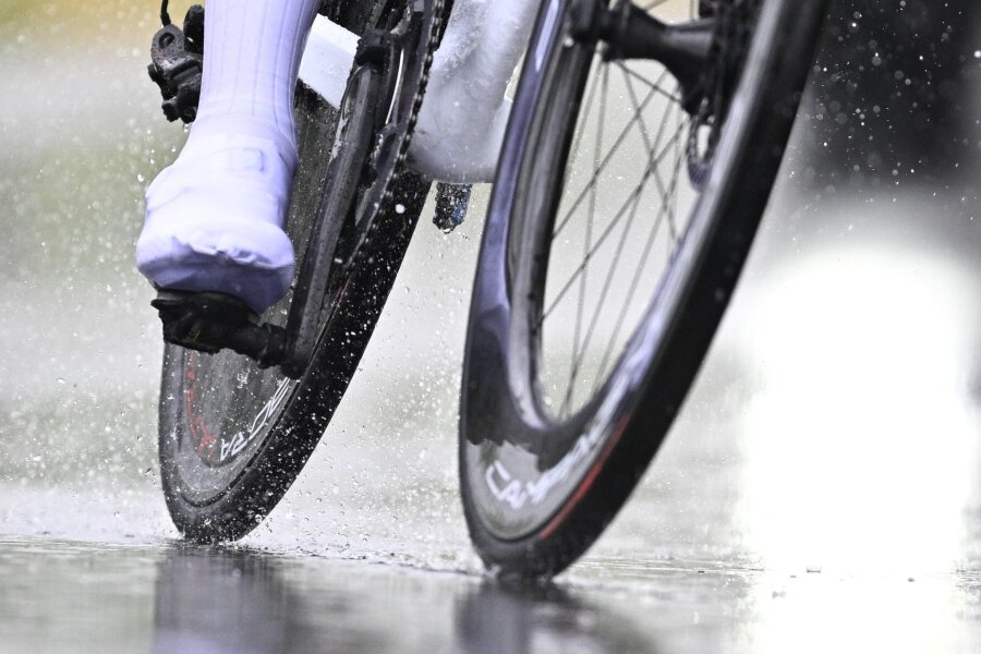 23 Jahre alter Fahrradfahrer von Auto erfasst und verletzt - Ein Radfahrer fährt bei Regen über eine Straße.