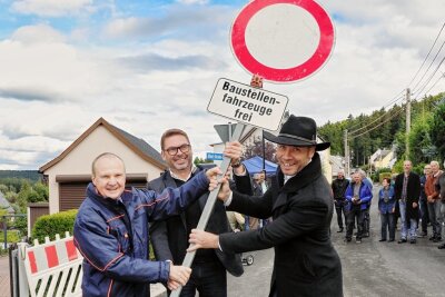 Weg mit der Vollsperrscheibe an der Albert-Straube-Siedlung in Grünhain. Frank Kippig, Bürgermeister Mirko Geißler und Ortsvorsteher Jens Ullmann (von links) haben die Baustelle aufgehoben. 