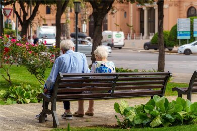 Altes Rentner Ehepaar sitzt in einem Park auf einer Parkbank. Wie wird das Rentensystem  der Zukunft aussehen?